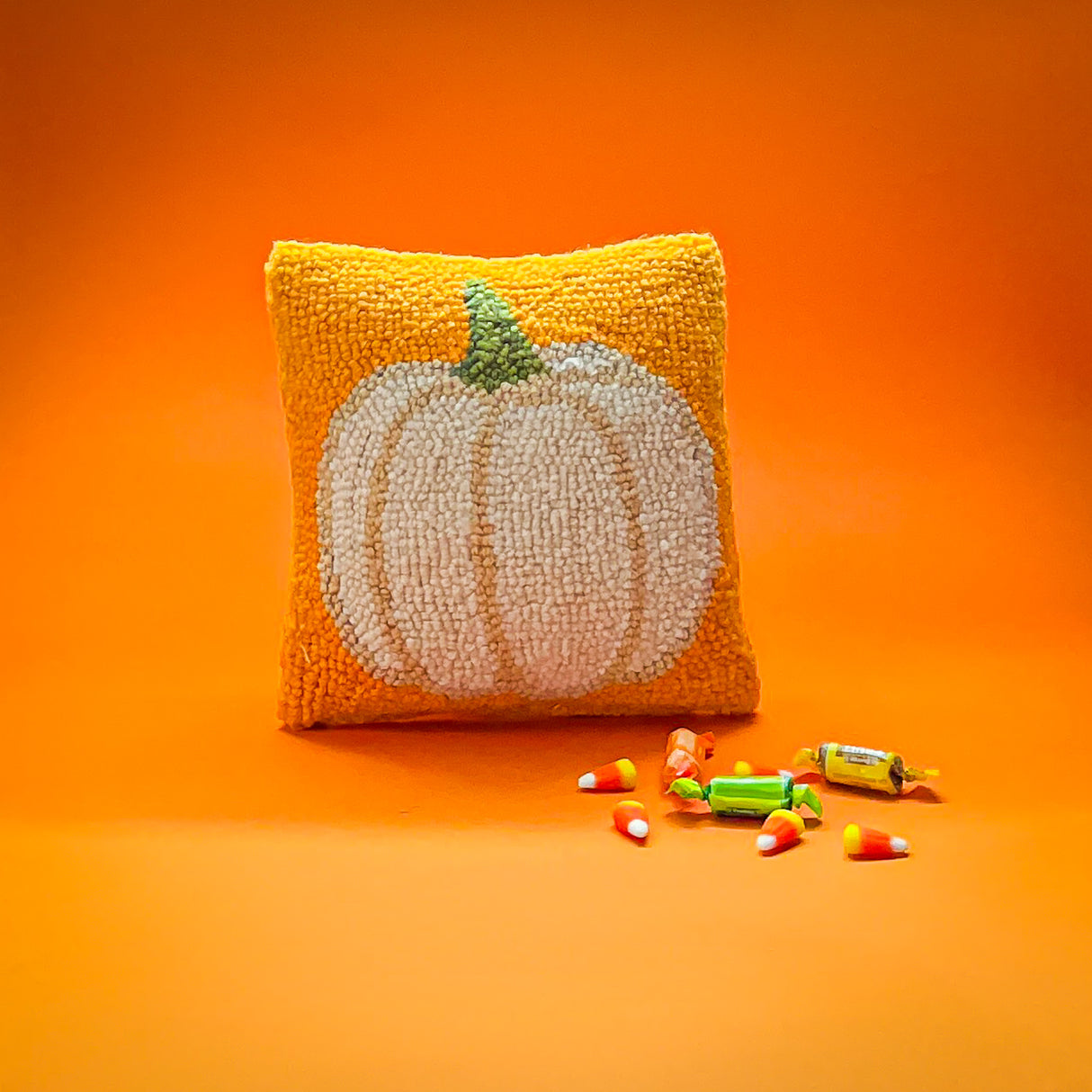 Madcap Cottage halloween throw pillow with a white pumpkin on an orange background 