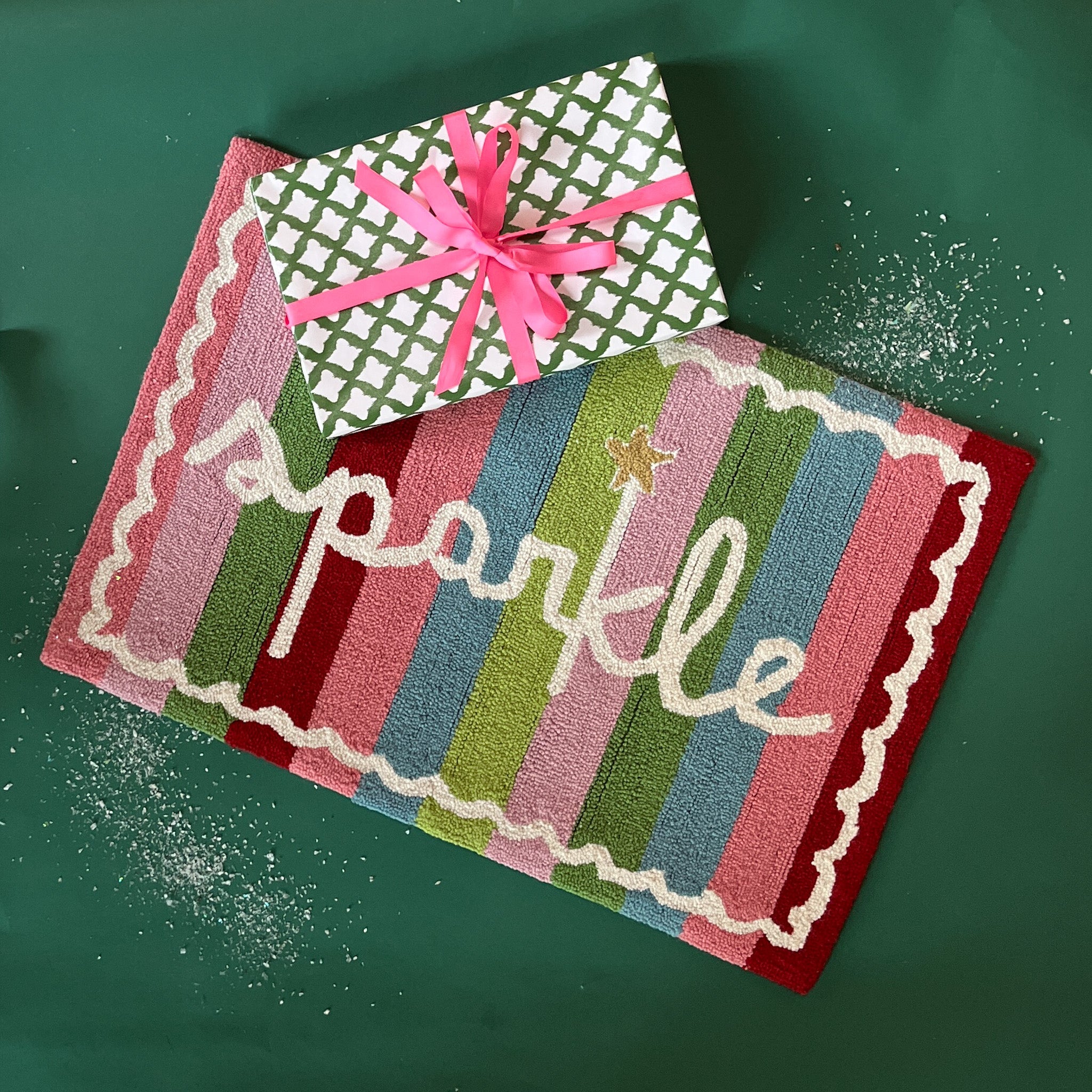 A striped rectantgular Christmas rug that says "sparkle" and has a white scalloped motif at the border