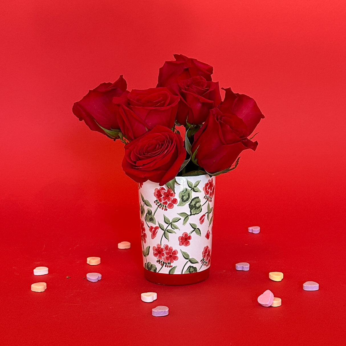 Glass with hand-painted red geraniums used for a glass or vase.