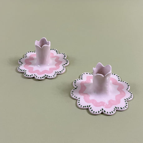 A pair of Scalloped ceramic candle holders with a pink and green wavy motif 