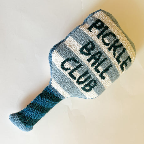 a paddle shaped pickeball pillow featuring blue and white stripes and text that reads "Pickle Ball Club"