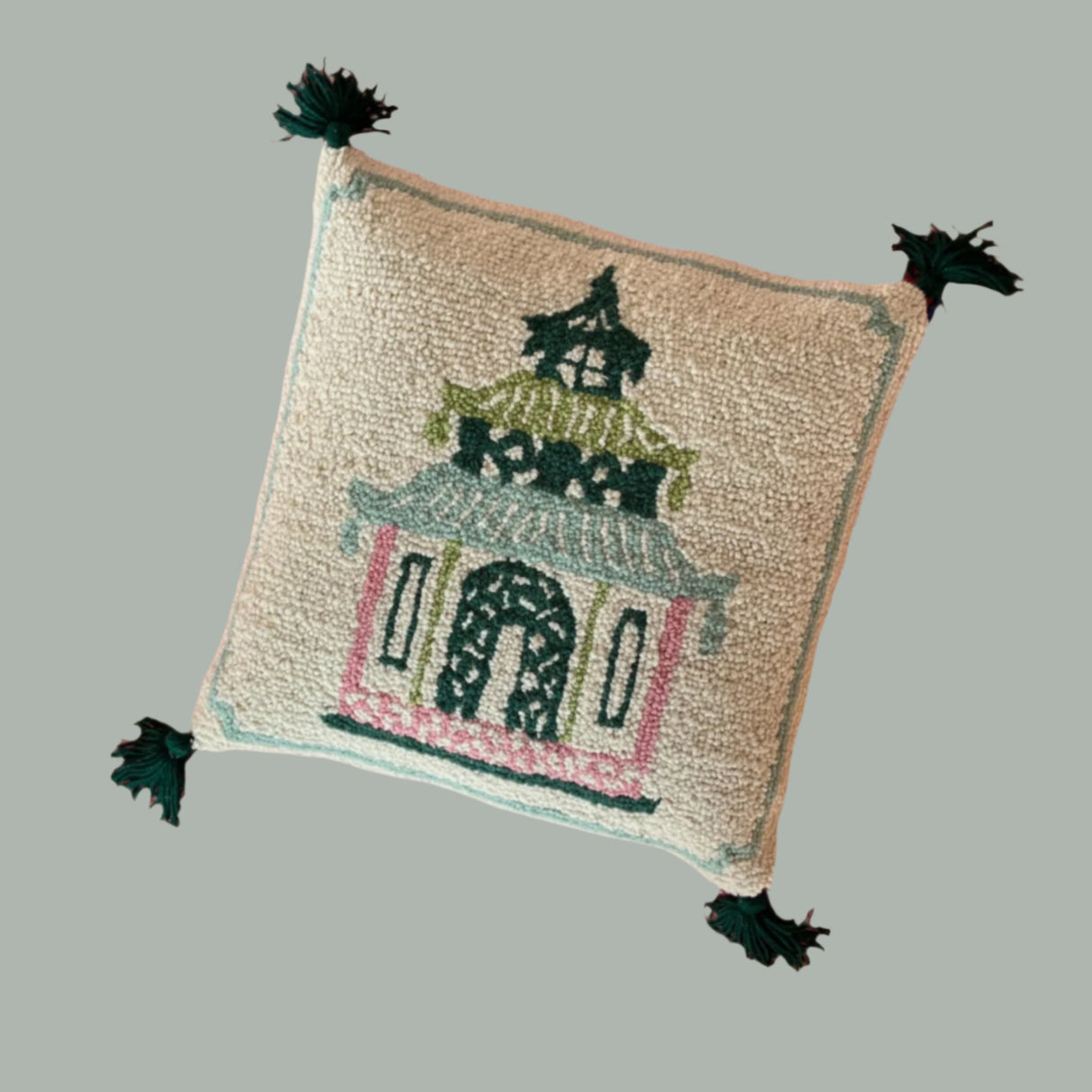 A madcap cottage cream cushion with a pink and green pagoda motif on it. 