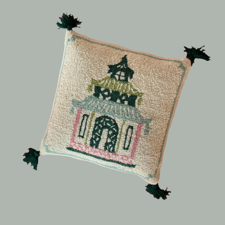 A madcap cottage cream cushion with a pink and green pagoda motif on it. 