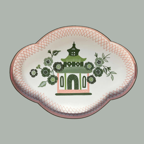 A pink and green metal tray featuring a central pagoda motif surrounded by blossoms. 