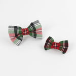 2 McNixon Red/White/Dark Green Plaid Dog/Cat Bowties in Medium and Large placed on a white surface