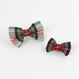 2 McNixon Red/White/Dark Green Plaid Dog/Cat Bowties in Medium and Large placed on a white surface