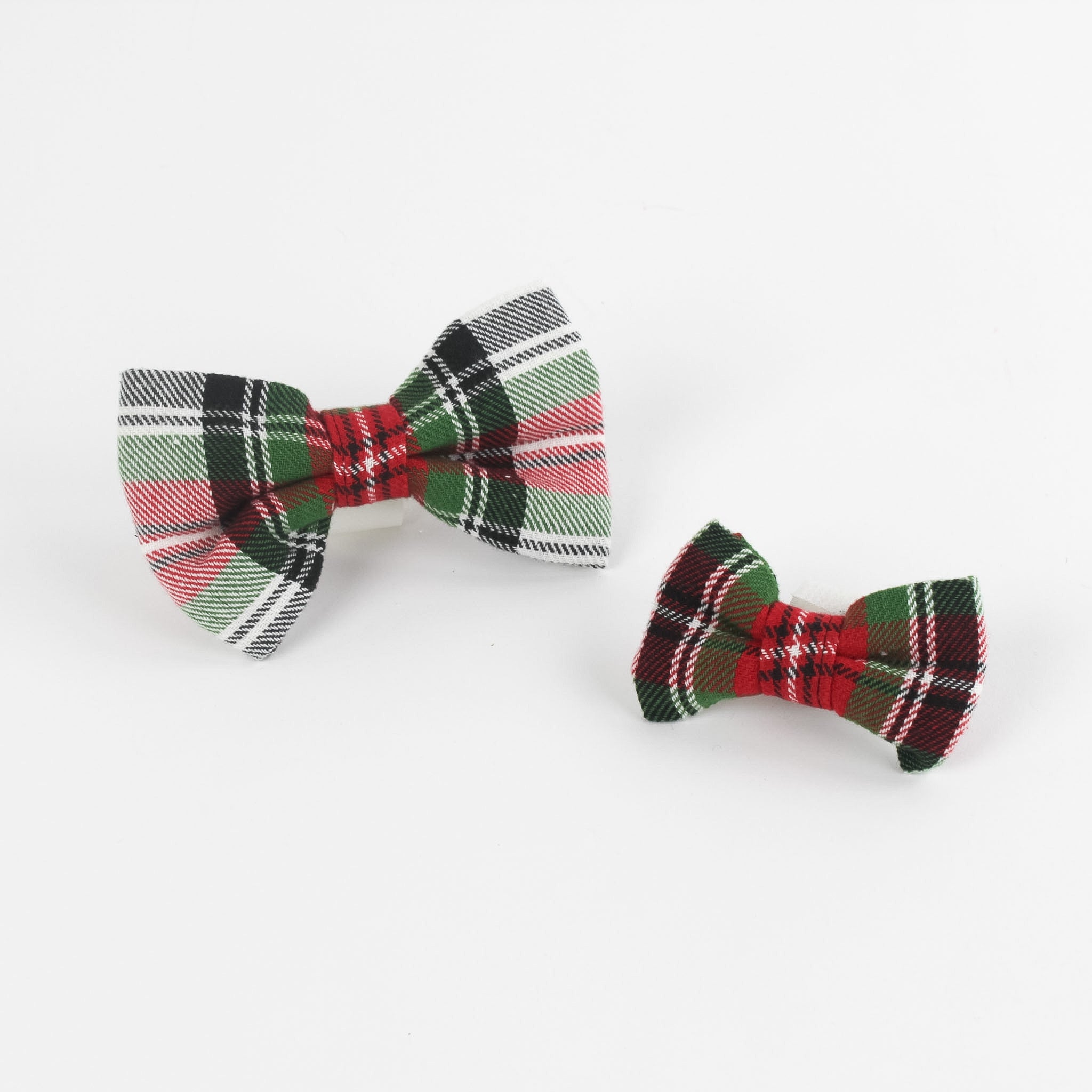 2 McNixon Red/White/Dark Green Plaid Dog/Cat Bowties in Medium and Large placed on a white surface