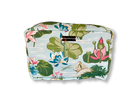 A medium-sized Meadow Club Sky Blue Cosmetics Bag with a floral pattern consisting of lotus flowers and leaves.