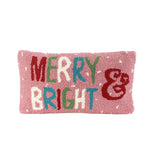 Front view of a pink “Merry & Bright” hooked wool pink christmas pillow with multicolored lettering.