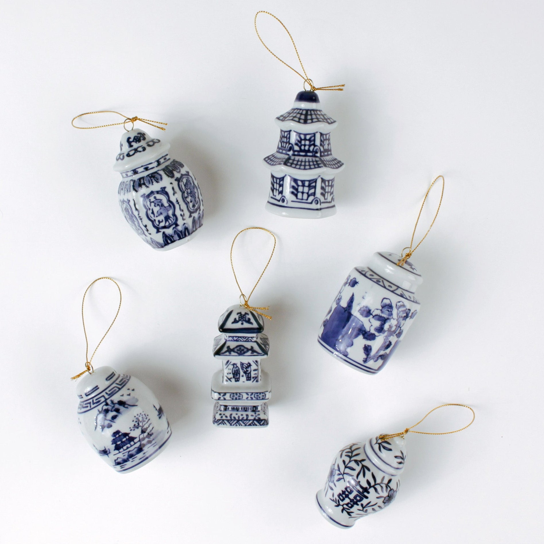Elegant blue and white porcelain Christmas chinoiserie ginger jar ornaments on a white background. 