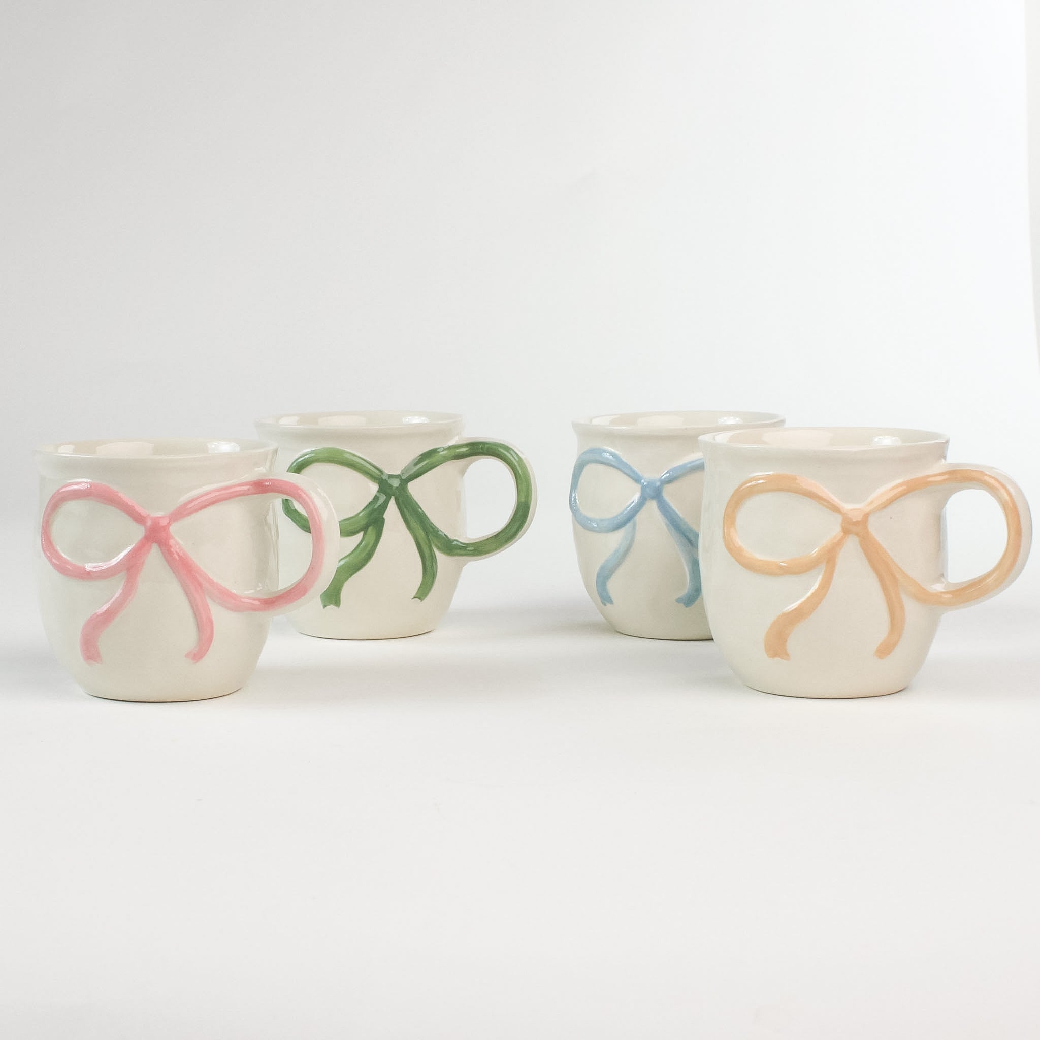 4 multicolored Ceramic Bow Mugs in a white background