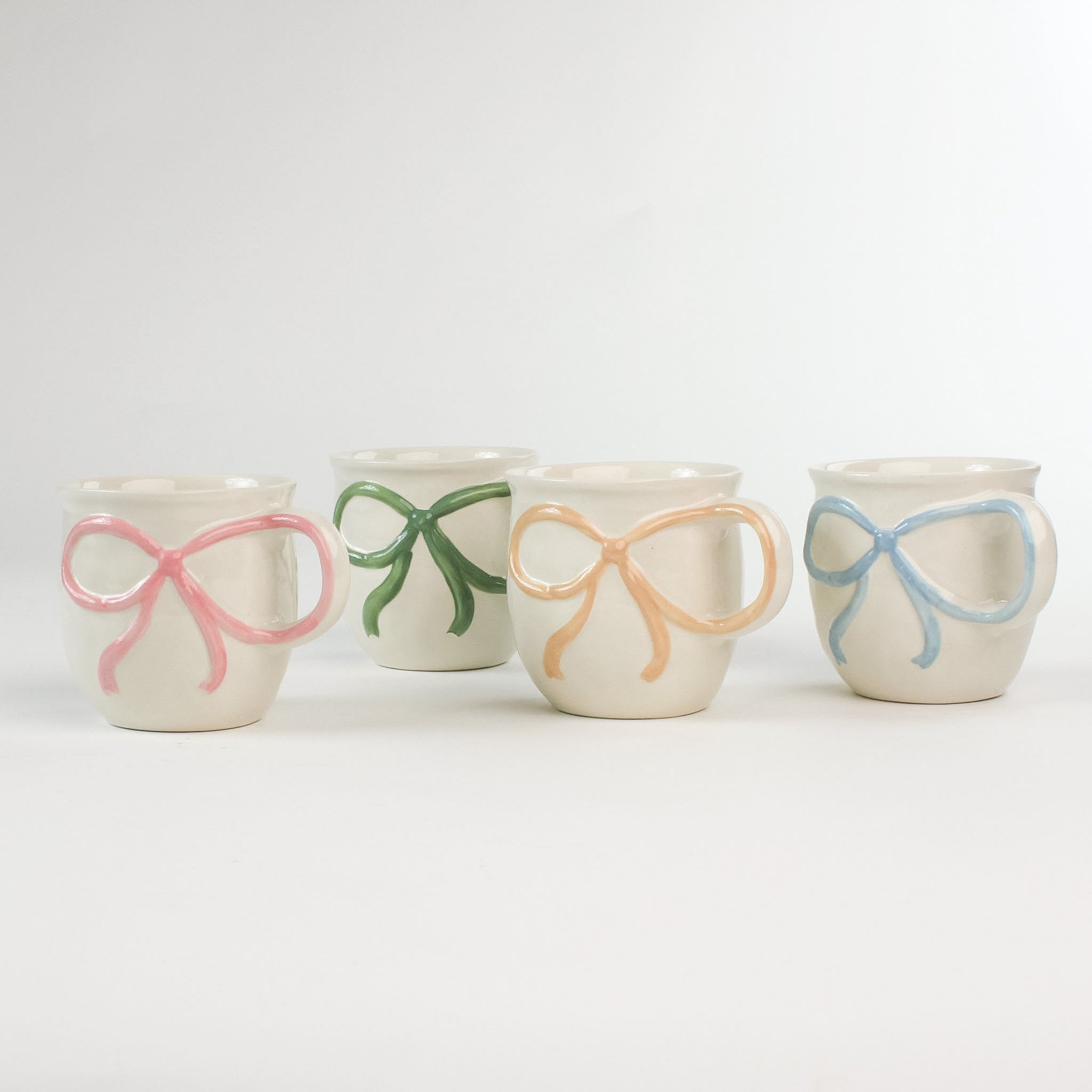 4 Multicolored Ceramic Bow Mugs in a white background
