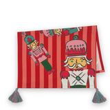 A folded rectangular red and pink striped tea towel, decorated with cartoon nutcracker illustrations and finished with two tassel ties at the bottom corners.