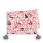 a folded pink christmas tea towel with nutcracker ballet motifs of swans, ribbons, christmas trees, ballerinas and nutcrackers against a white background. 