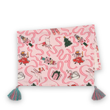 a folded pink christmas tea towel with nutcracker ballet motifs of swans, ribbons, christmas trees, ballerinas and nutcrackers against a white background. 