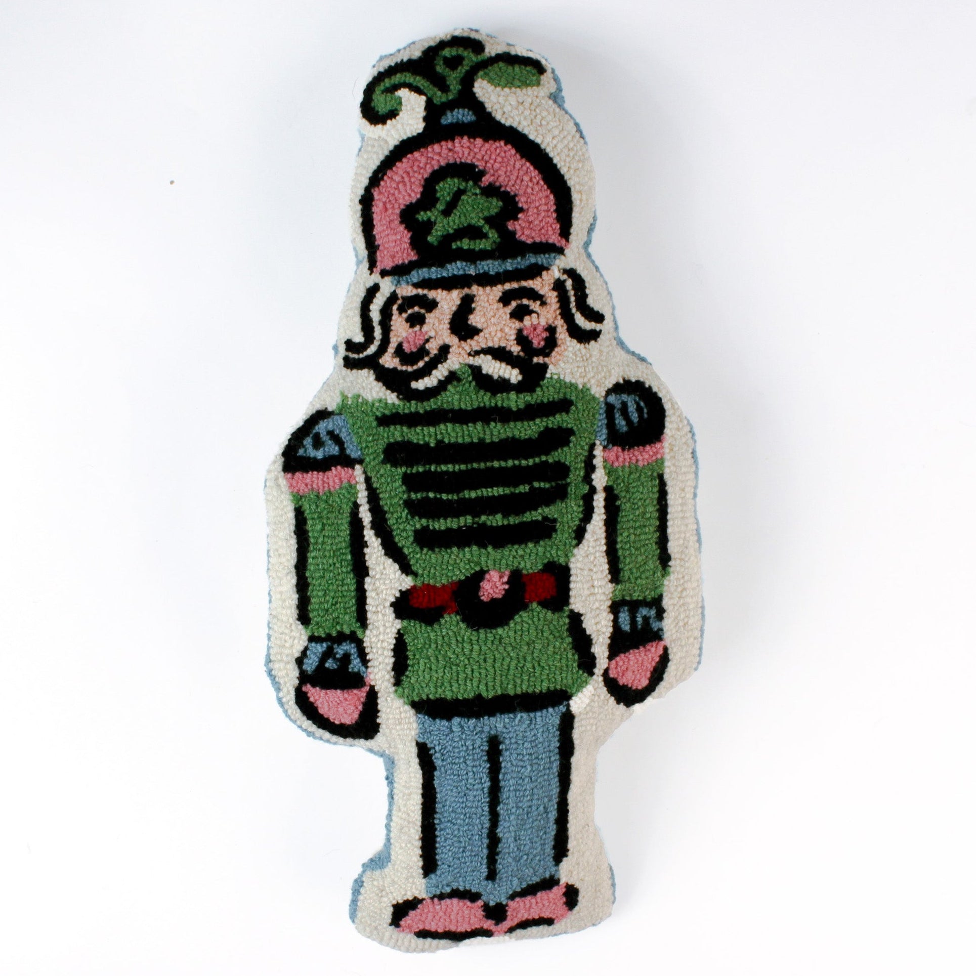 Decorative Christmas pillow shaped like a nutcracker soldier, featuring a pastel green uniform, pink and blue accents, and a detailed mustached face with a tall plumed hat.