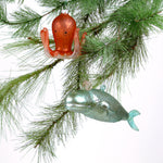Decorative whale and octopus glass christmas ornaments on a white background