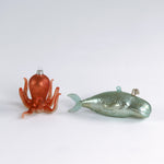 back of a Decorative whale and octopus glass christmas ornaments on a white background