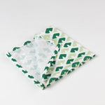 Folded green and light green patterned cloth napkin showing inside seam and fabric texture for table decor.