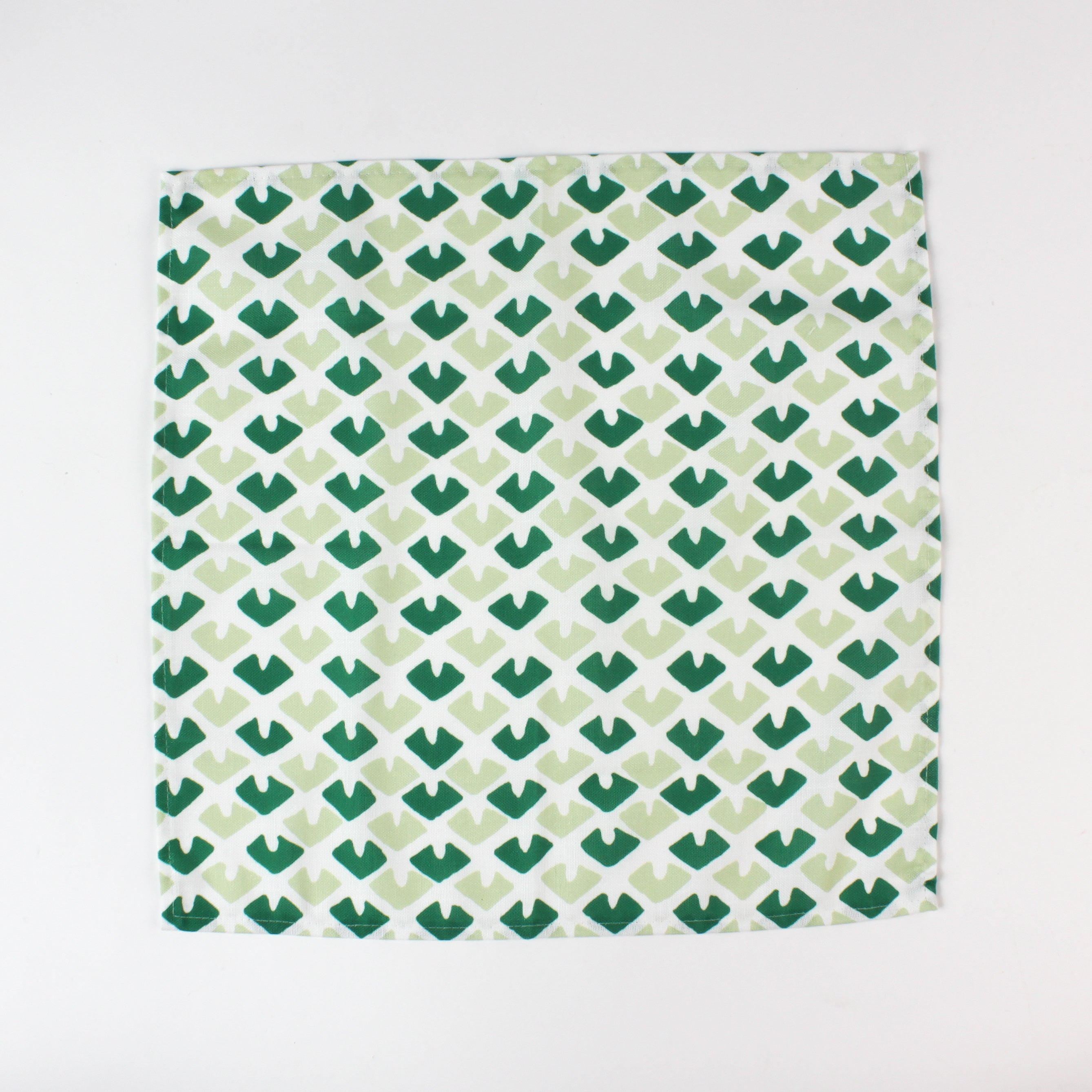 Green and light green patterned cloth napkin showing inside seam and fabric texture for table decor.