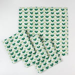 Green geometric patterned cloth napkins set with matching large dinner napkin, folded and displayed on a white background.