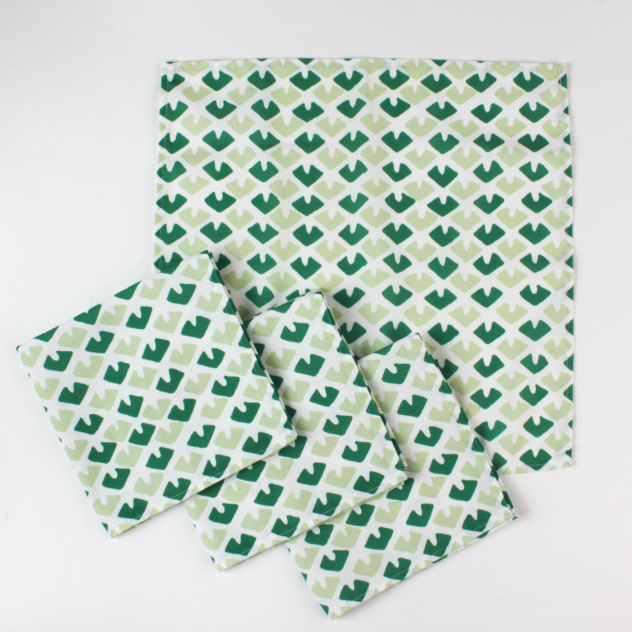 Green geometric patterned cloth napkins set with matching large dinner napkin, folded and displayed on a white background.