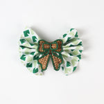 Green print fabric napkin styled with woven rattan bow napkin ring for table décor.