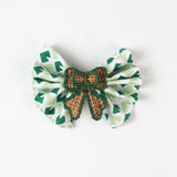 Green print fabric napkin styled with woven rattan bow napkin ring for table décor.