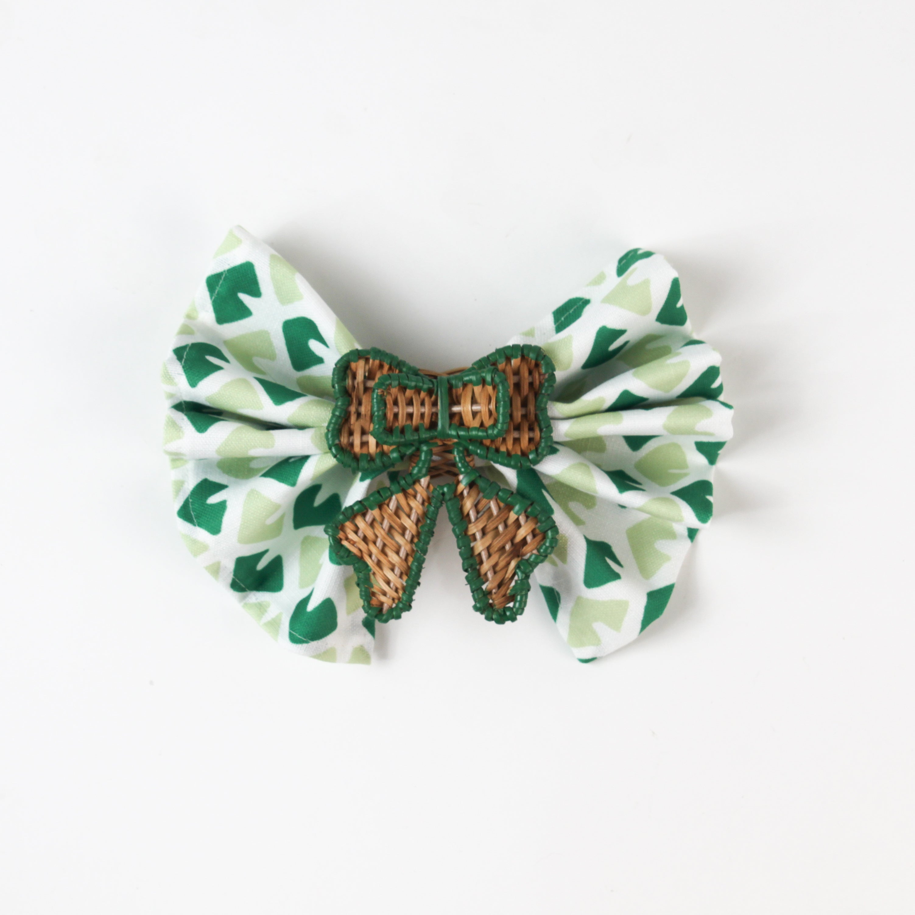 Green print fabric napkin styled with woven rattan bow napkin ring for table décor.