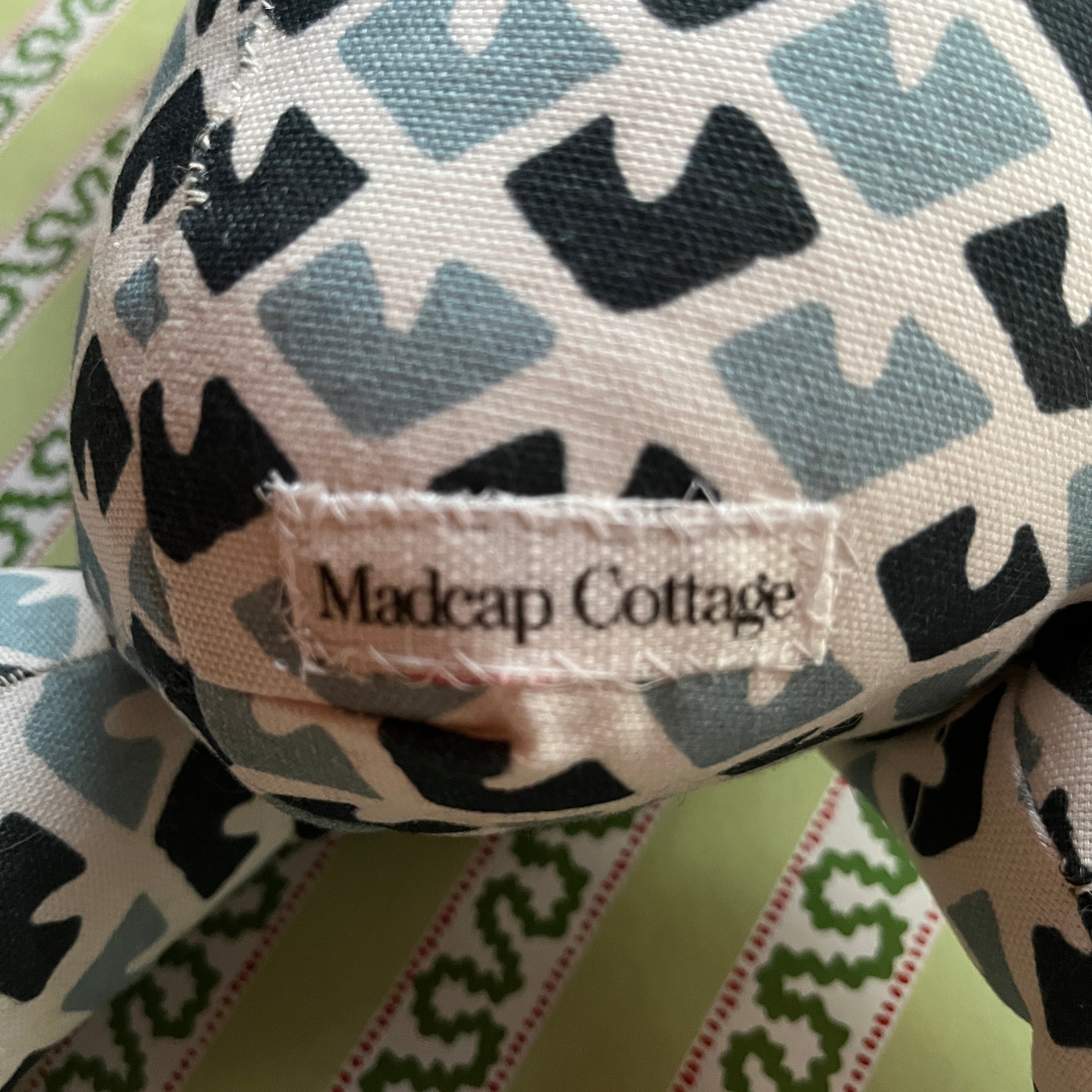 Close-up 
Blue and white patterned stuffed elephant toy with a green bow.