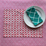 Old Jaipur red cloth placemat with a white plate and napkin resting on it.