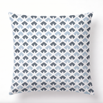 a square blue and white pillow featuring a triangle block print motif in dark blue and light blue. 
