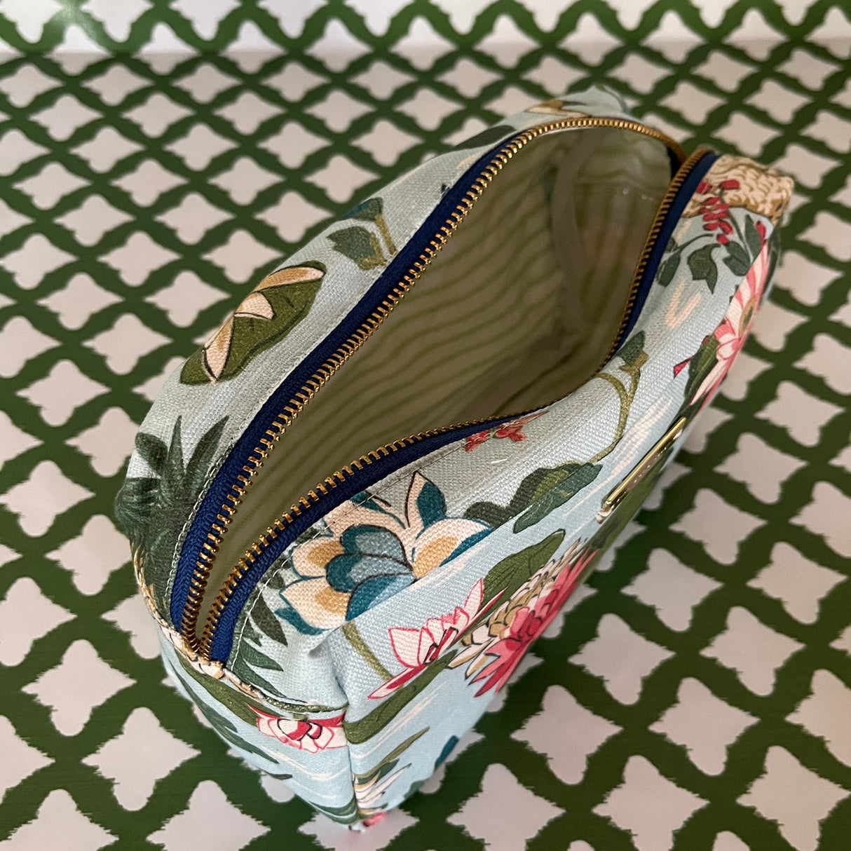 Open view of Meadow Club toiletry bag in sky blue features a lily pond pattern