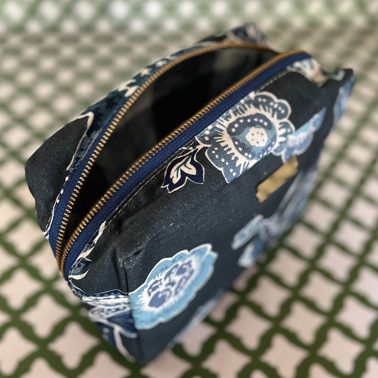 Open view of Temple Garden toiletry bag in navy blue features light blue floral motif.
