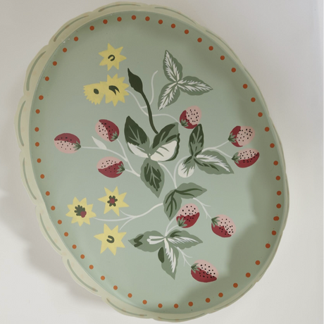 a light green strawberry tray with the base painted with strawberry and yellow flower motifs.
