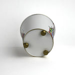 Bottom view of white tole cachepot with gold feet and gold-trimmed base.