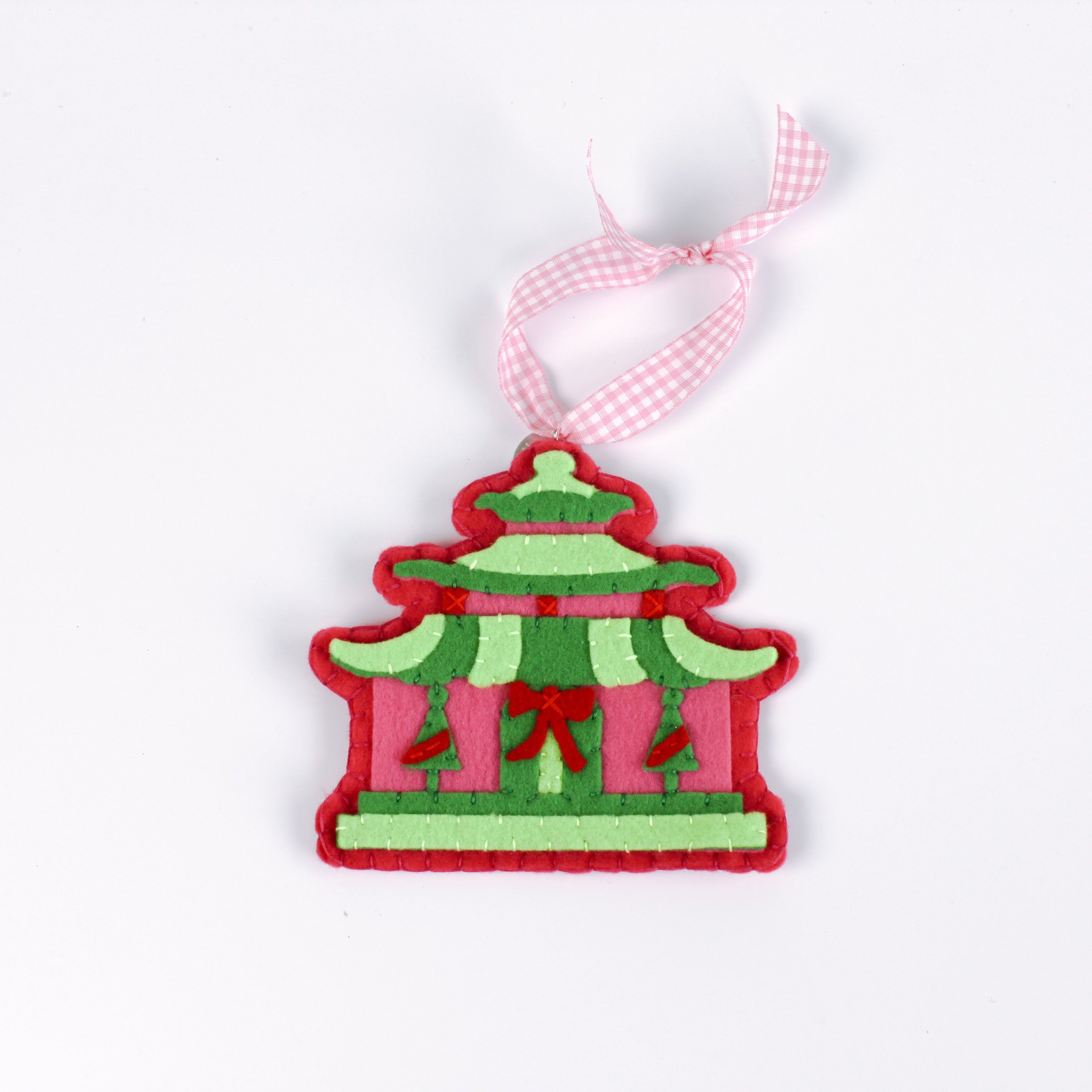 pink felt chinoiserie christmas ornaments in the shape of pagodas against a white background 