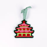 pink felt chinoiserie christmas ornaments in the shape of pagodas against a white background 