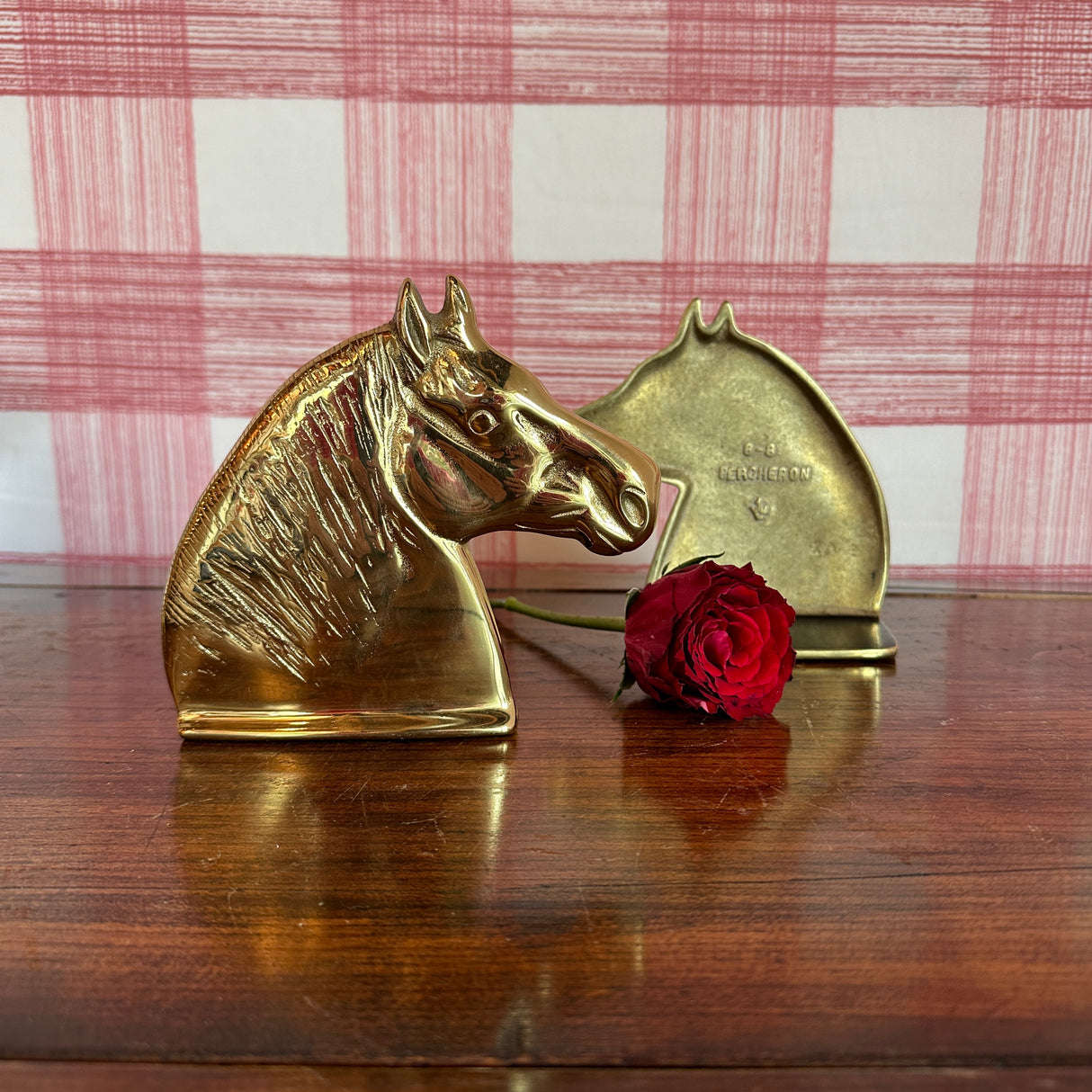 A pair of brass horse bookends with the reverse side shown of one bookend. 