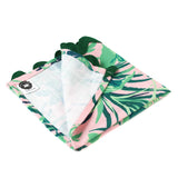 Palm leaf print napkin with green tropical foliage on a soft pink background and scalloped edge, stylish table linen perfect for Christmas tea towel styling, holiday entertaining, and seasonal home décor