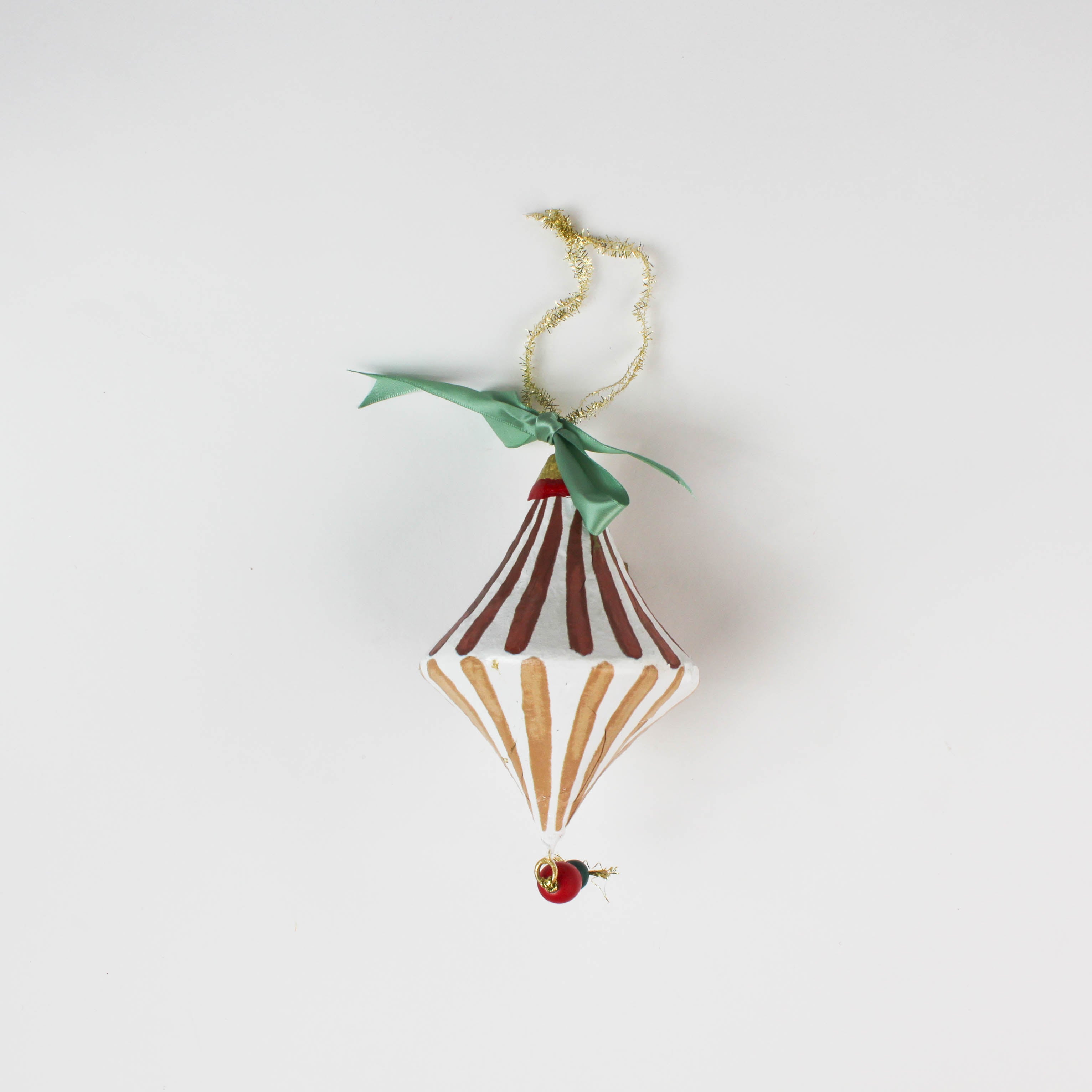 paper mache red striped christmas ornament on a white background