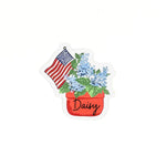 Patriotic place card featuring blue hydrangeas in a flower pot with an American flag and handwritten name on a white background.