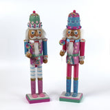two pink and blue christmas nutracker table decorations on a white background