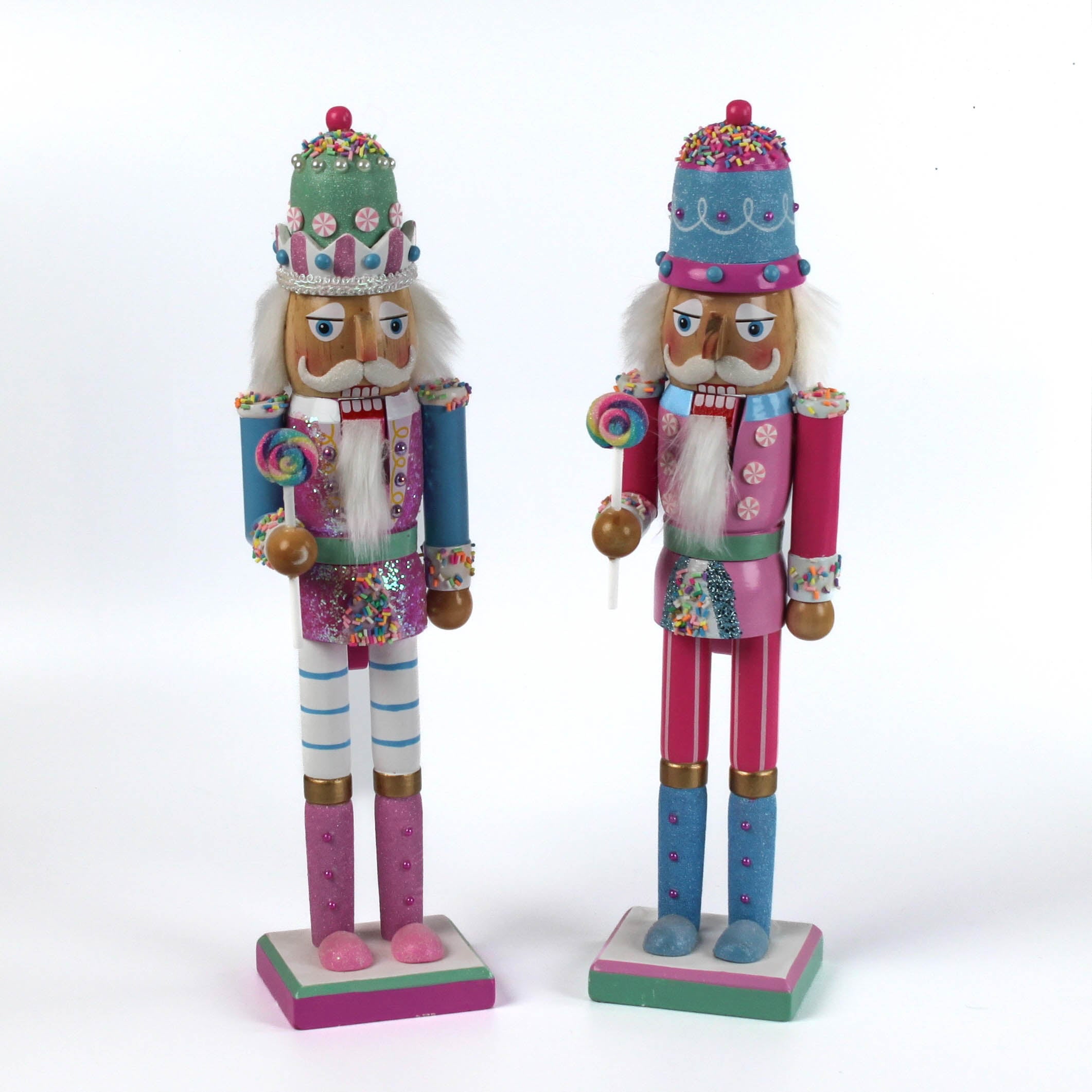 two pink and blue christmas nutracker table decorations on a white background