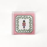 Nutcracker Square Acrylic Tray with in small size with pink and green border and Nutcracker in the center.
