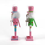 side view of two Pink and Green Christmas Nutcracker Table Decorations against a white background. 