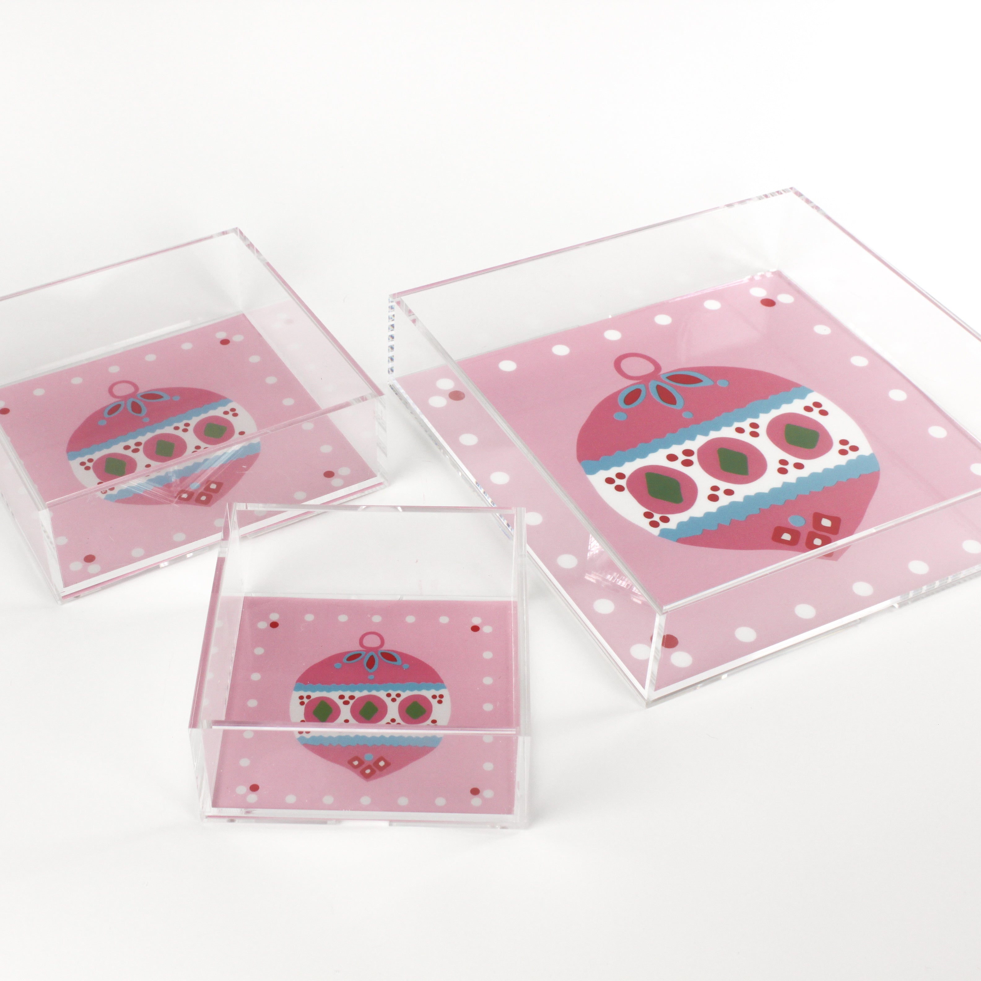 a pink square Acrylic Trays in different sizes with Ornament motifs on them on a white background