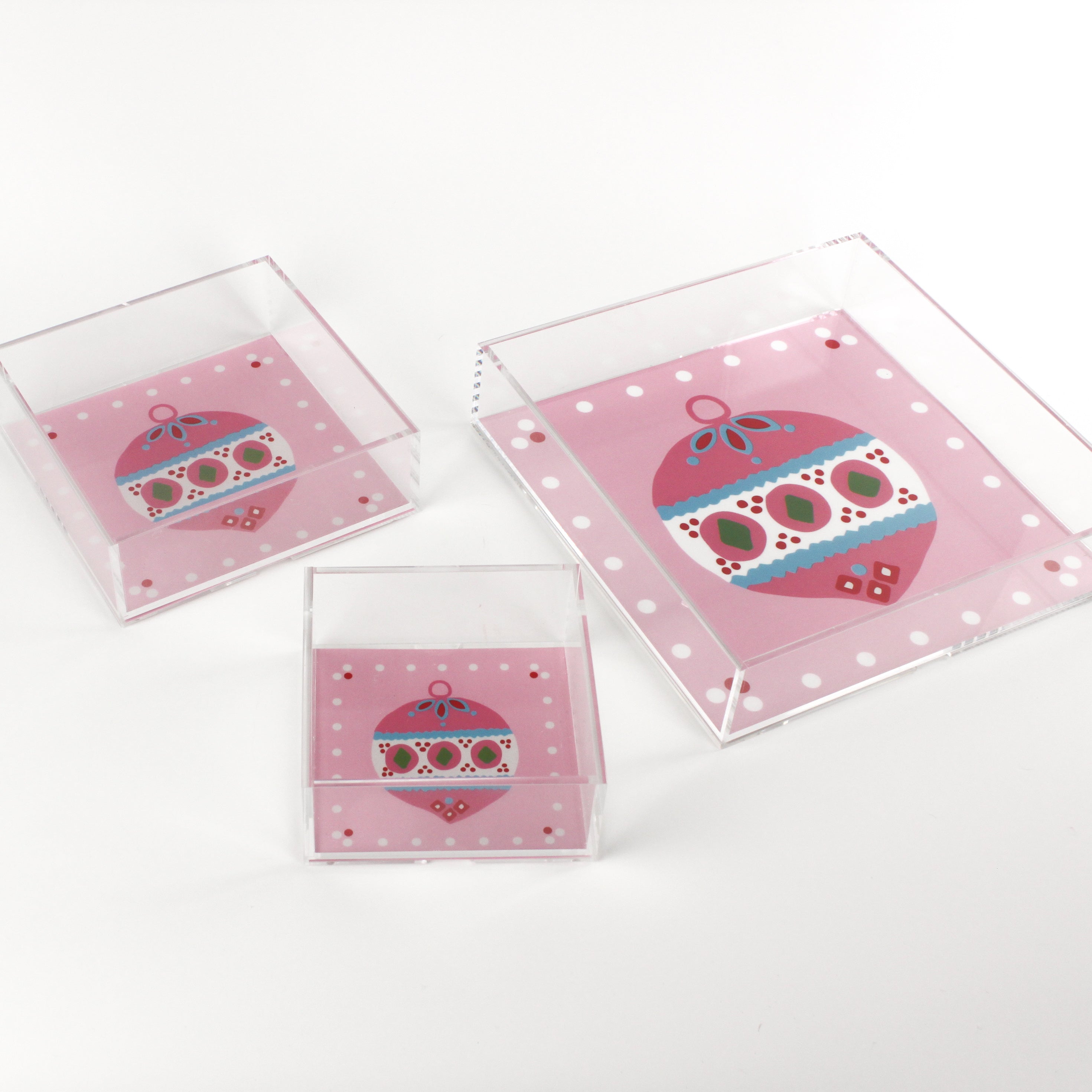 a pink square Acrylic Trays in different sizes with Ornament motifs on them on a white background