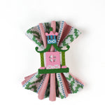 A pink and green chinoiserie napkin ring filled with a pink and green striped napkin from madcap cottage