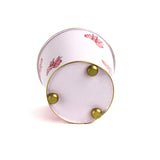 Bottom view of pink tole cachepot with gold feet and gold-trimmed base.